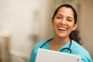 a woman in a blue scrubs holding a clipboard