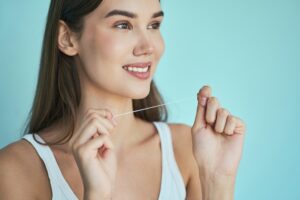 a woman holding a dental floss