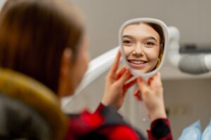 a woman looking at her face in a mirror