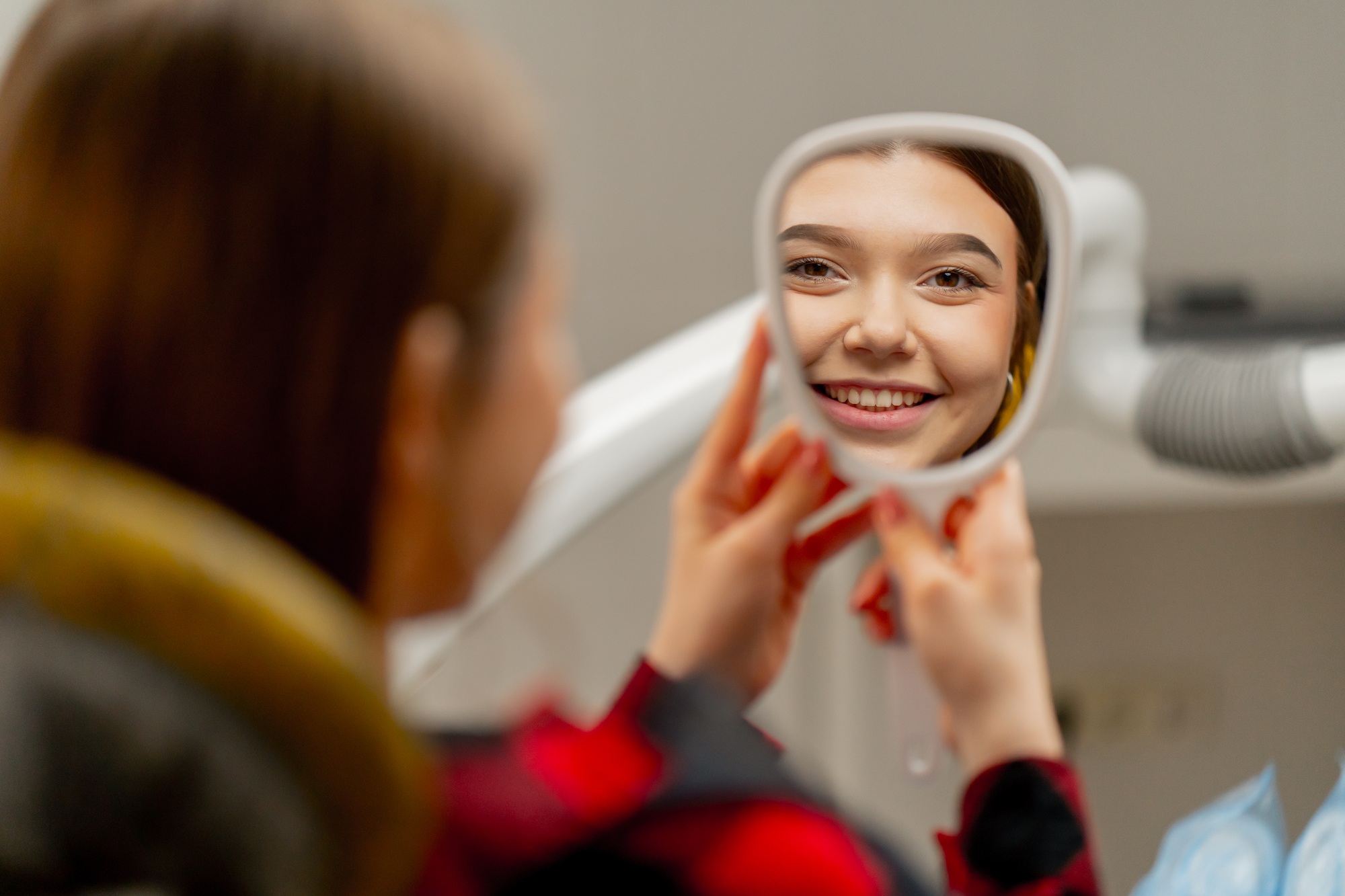 a woman looking at her face in a mirror